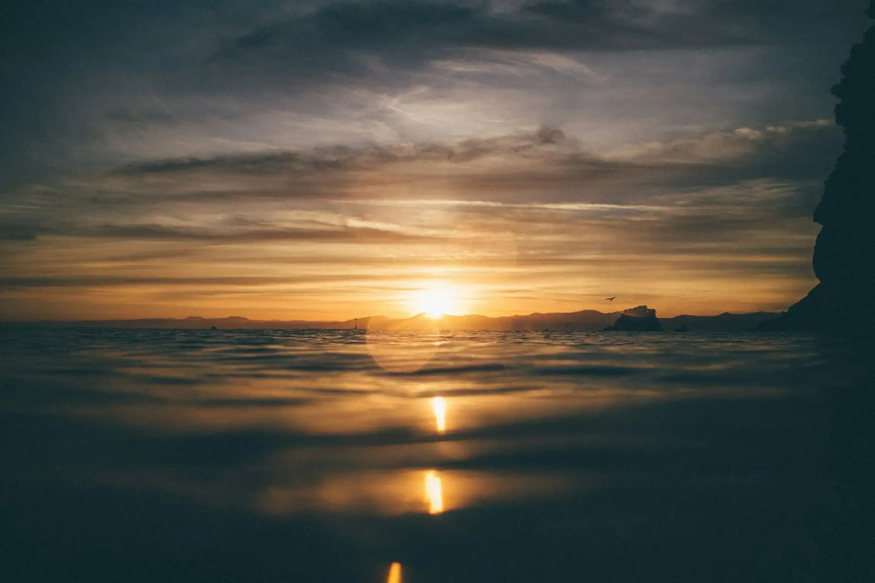 Low golden sun at dusk, the horizon softening into haze.