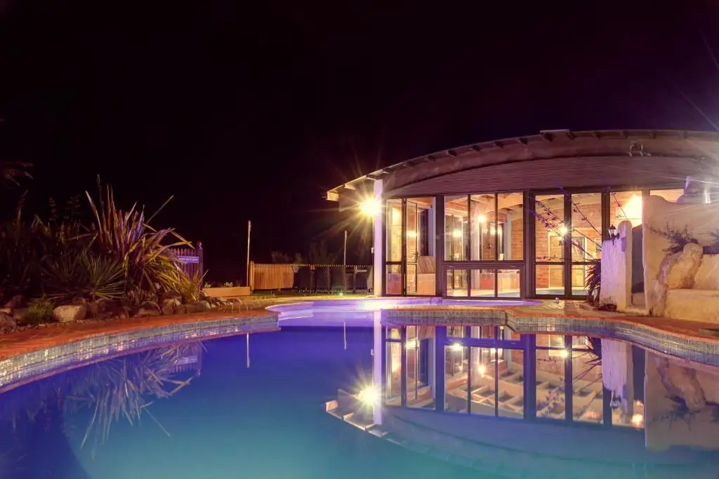 The heated pools at Kimi Ora, lit at night.